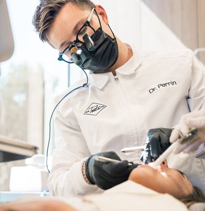 Dr. Connor Perrin, a cosmetic dentist in Irvine, CA, applying dental bonding to an Orange County patient