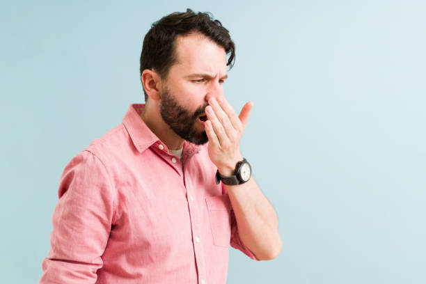 a man trying to smell his breath