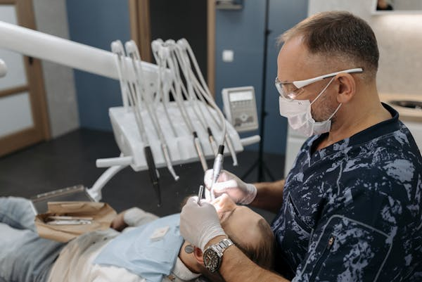 image of a dental professional performing a dental scaling on a patient